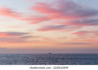 Single Fishing Trawler Boat Goes Out At Sunrise With Beautiful Colors And Clouds Formations In Cornwall England