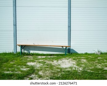 Single Foldable Beer Tent Bench On A Lawn On A Lightweight Wall. 