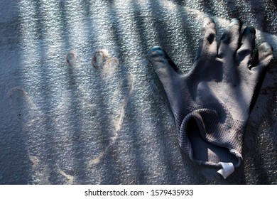 Single Garden Glove And A Handprint On A Tempered Glass Table. Conceptual, Mysterious Photography.