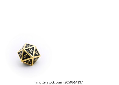 A Single Gold and Black d20 (Twenty-Sided Die) in Lower Left Corner Isolated on White with Copy Space