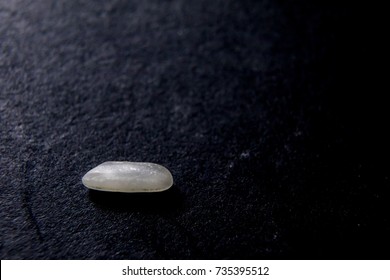 A Single Grain Of Rice On Black Background