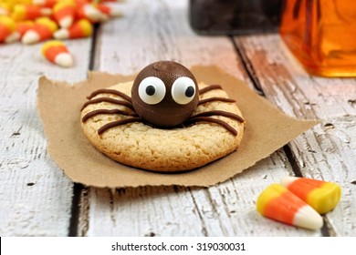 Single Halloween Spider Cookie On A Rustic White Wood Background With Candy Corn