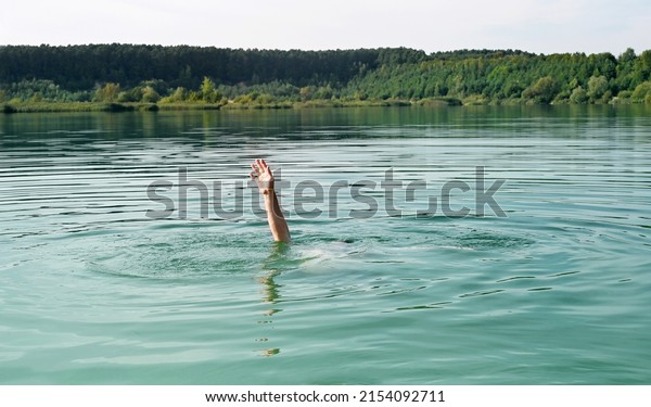 Single\
hand of drowning man in water asking for\
help.