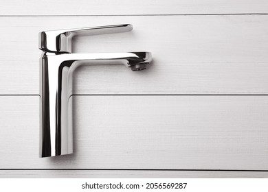 Single Handle Water Tap On White Wooden Table, Top View. Space For Text