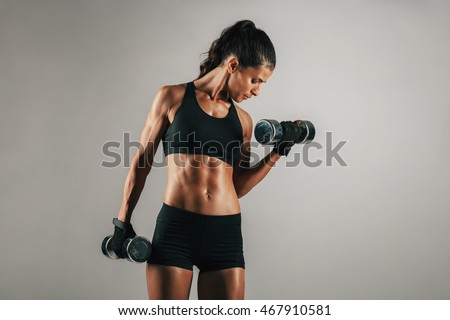 Similar – young adult trained woman concentrate at her excercise in gym