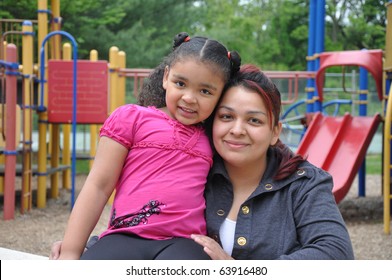 Single Hispanic Mom With Biracial Child On Playground