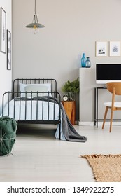 Single Industrial Bed With Blue Bedding In Stylish Grey Bedroom, Copy Space On Empty Wall