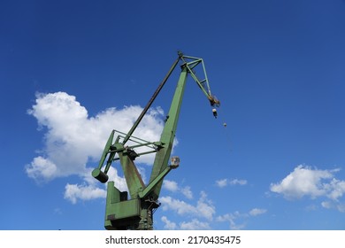 A Single Isolated Green Crane Silhouette During The Day In The Shipyard 