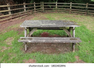 Single Isolated Picnic Bench With No People. Solo Wooden Picnic Bench Surrounded By Wooden Fencing. Empty Bench In Country Park Picnic Garden With Nobody Sitting Down. 