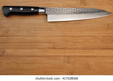 Single Japanese Professional Long Kitchen Knife On The Bamboo Empty Cutting Board, Top View, Close Up, Copy Space