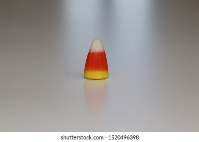 Single Kernel Of Candy Corn On Light Surface