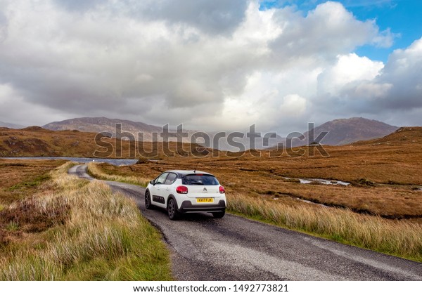 Single lane
road, Scotland, UK - April 10, 2019: car driving on the narrow one
lane road in rural Scottish
Highlands