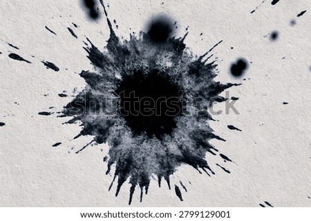 Single large black ink splash blot on white paper