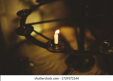 Single Lit Candle On Stand In The Dark