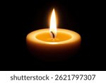 A single, lit candle sits in the center of a black background its warm yellow flame casting a soft glow.