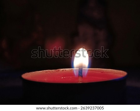 A Single Lit Tealight Candle in the Dark
