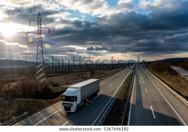 Single lorry truck on country highway under a\
beautiful sky