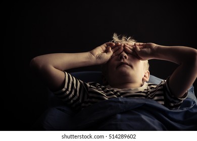 Single Male Child Rubbing Eyes While Laying In Bed