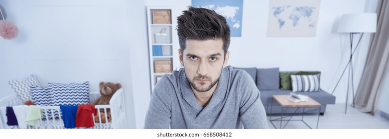 Single Man In Living Room Overworked By Home Duties