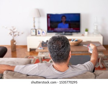 Single Man On The Couch Watching Tv, Changing Channels