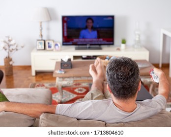 Single Man On The Couch Watching Tv, Changing Channels