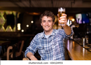 Single Man In A Pub Or Bar Holding The Beer High In The Air