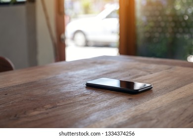 A Single Mobile Phone On Wooden Table 