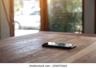 A Single Mobile Phone On Wooden Table 