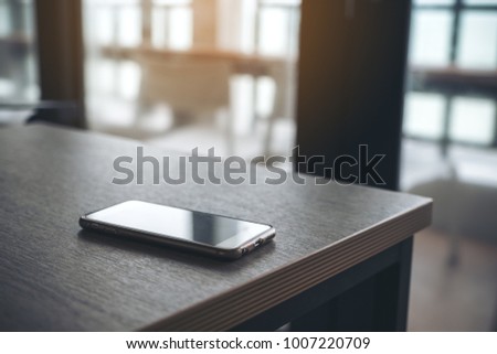 A single mobile phone on wooden table in the office