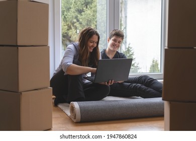 
Single Mom With A Teenage Son Looking At Their New Apartment On The Laptop Before Moving