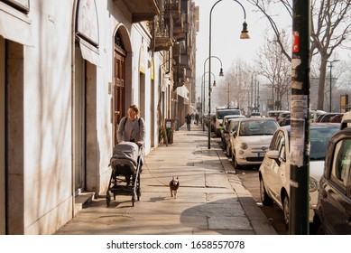 Single Mom Walking With Her Child And Dog On The Street. Torino, Italy - 18 February 2020