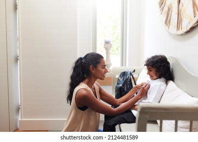 Single Mother At Home Getting Son Wearing Uniform Ready For First Day Of School Close In