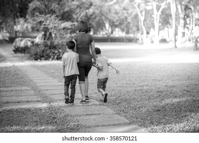 Single Mother Walking In The Park With Sons Black And White