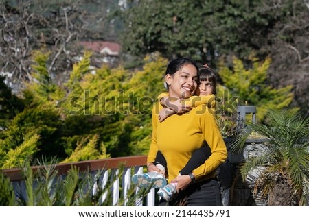 Single mother, woman, female, girl playing, cuddling, smiling, hugging, holding  cute beautiful lovely girl, child, kid, daughter in garden, vacation, hill station, picnic. Sukanya Samriddhi yojana