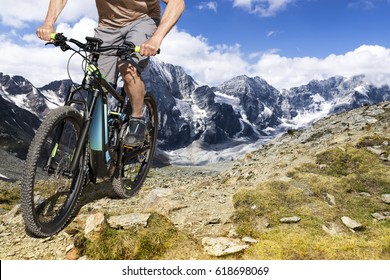 Single mountain bike rider on ebike rides up a steep mountain trail. - Shutterstock ID 618698069