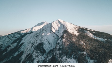 Single Mountain In The Canadian Rocky Mountains. Boreal Forest Surrounding The Mountain Before You Reach The Treeline At The Summit Where You Reach Snow And Ice Making It A Boreal Zone. (AERIAL/DRONE)