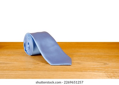 single necktie rolled isolated over wooden surface with white background, single object close up view, male fashion clothing display concept, copy space for texting and commercial usage  - Shutterstock ID 2269651257