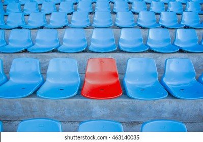 Single Or One Red Seat Or Bench In The Middle Or Center Of Blue Chair In The Football Or Soccer Stadium.