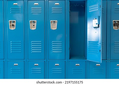 Single open empty blue metal locker along a nondescript hallway in a typical US High School.  No identifiable information included and nobody in the hall.  	
