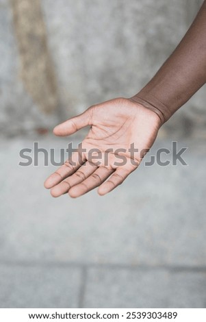 A single open hand reaching out against a textured background, symbolizing trust.