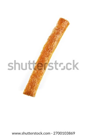 Single orange dried fruit leather stick isolated on white background, healthy natural snack food with chewy texture