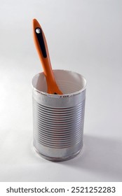 A single paint brush in a can of white paint