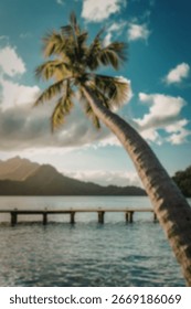 A single palm tree leans dramatically over a tranquil lagoon, a wooden dock stretching across the calm water towards lush green mountains under a partly cloudy sky.
