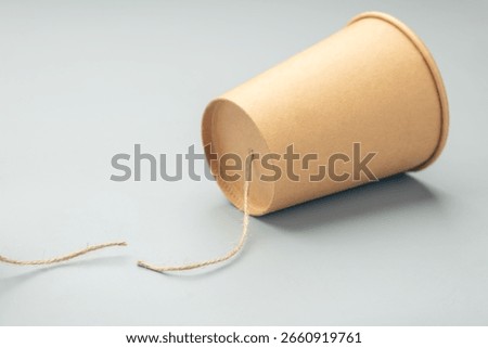 Single paper cup with a cut string, representing broken or one-sided communication, silent treatment, or lack of response