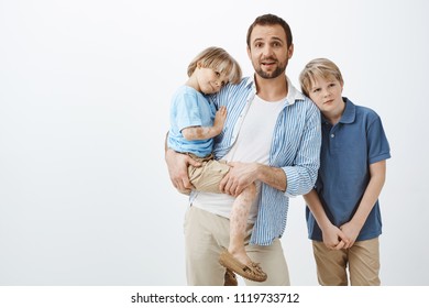 Single Parent Looking After Sons. Dad Holding Cute Child With Vitiligo While Staring Nervously At Camera, Being Left Alone With Two Boys, Clueless How Take Care Of Kids, Brother Leaning On Shoulder