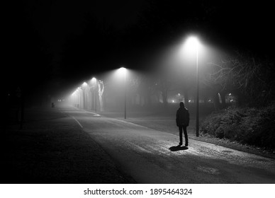Single Person Walking on Illuminated Street in the Dark Night - Shutterstock ID 1895464324