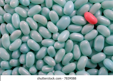 A Single Pink Jelly Bean In A Cluster Of Blue Jelly Beans.