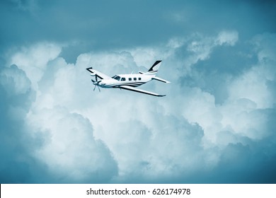 Single Piston Aircraft. Single-propeller Aircraft Flying Over The Blue Sky. Single Turboprop Aircraft.. Small Private Plane Flying In Blue Clouds.