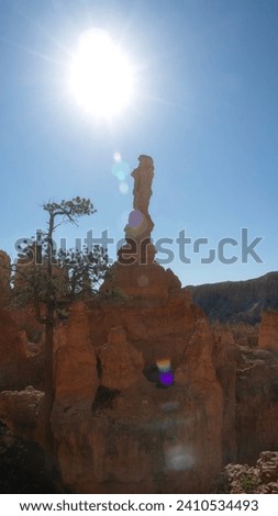 A single pointy colorful sandstone hoodoo rock formation on a hike in a National Park in southern Utah, USA on a bright sunny summer day