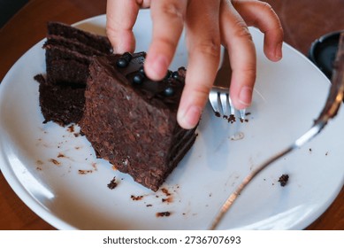 A single portion of dense chocolate cake accompanied by metal forks